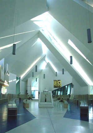 La chiesa vista dallo spazio retrostante l'ambone; a pavimento,  leggibile la sagoma dell'ictus che definisce il cuore dell'assemblea (archivio Archicura).