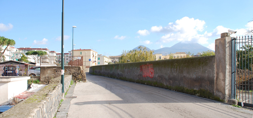 Portici, il muro di recinzione di Villa Mascolo, a nord della chiesa, e sullo sfondo il Vesuvio.