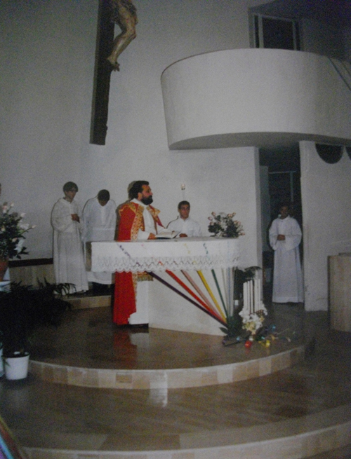 Il sacerdote allaltare nellassetto originario; si noti in particolare larticolazione della loggia sopra lambone e sopra la porta della sacrestia (archivio parrocchiale)