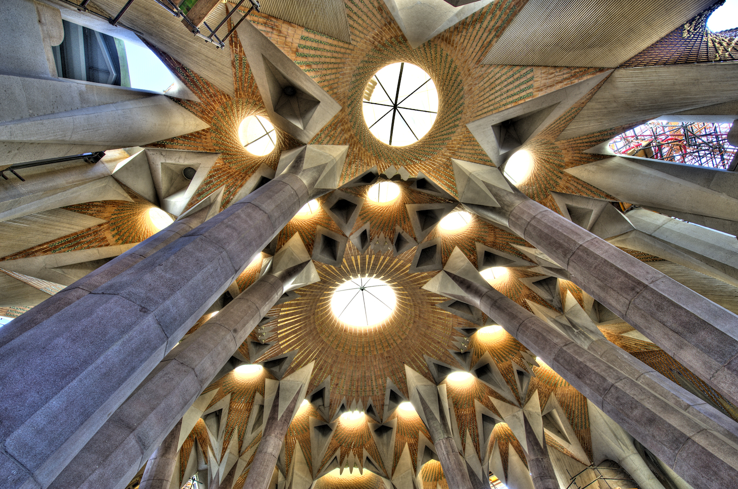 Sagrada Familia, vista delle volte rette da colonne arboree e composte da torrecotte e tessere colorate e dorate, disposte in forma di corone.